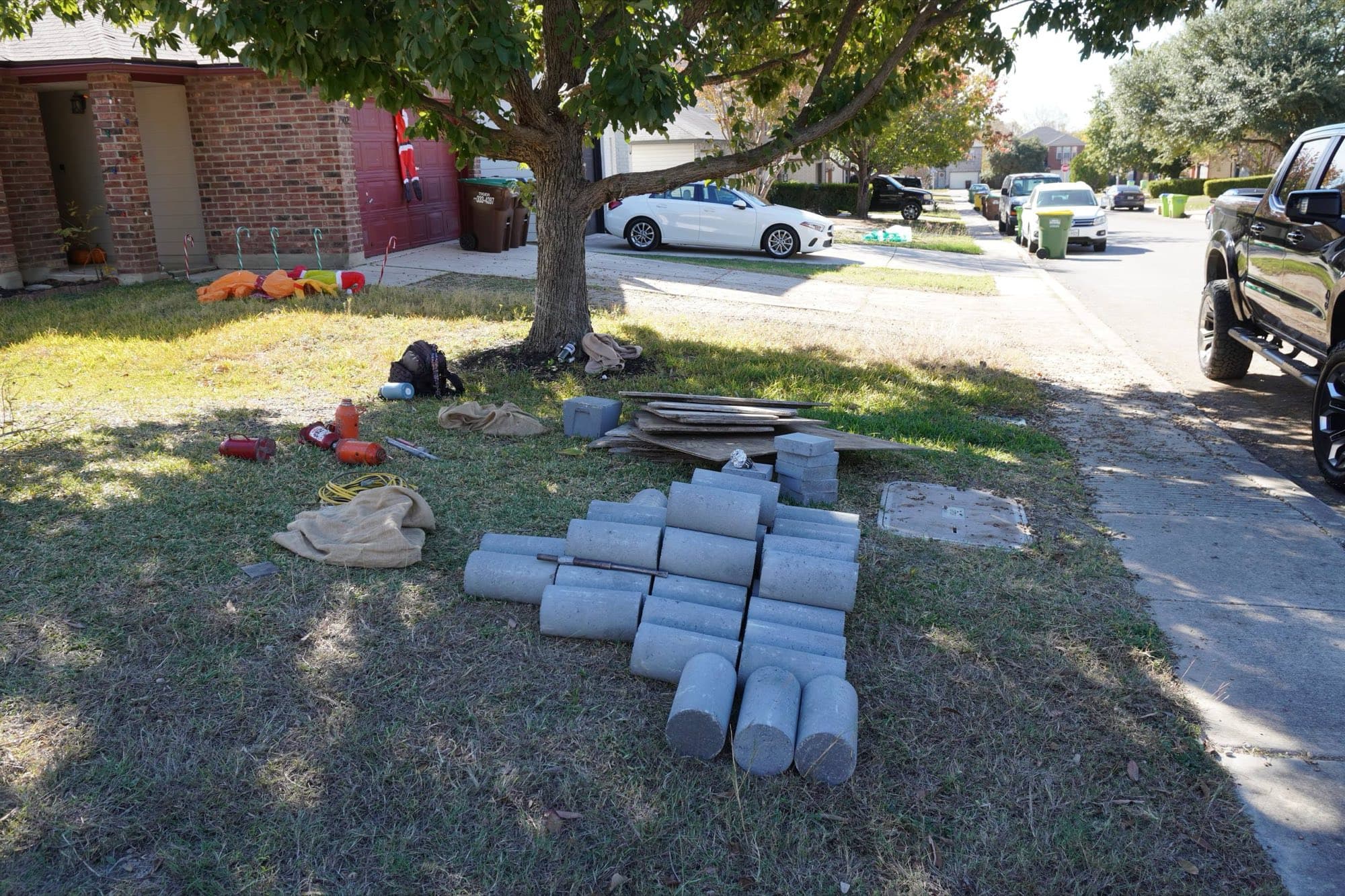 Concrete pressed piling cylinders staged on a front lawn before installation