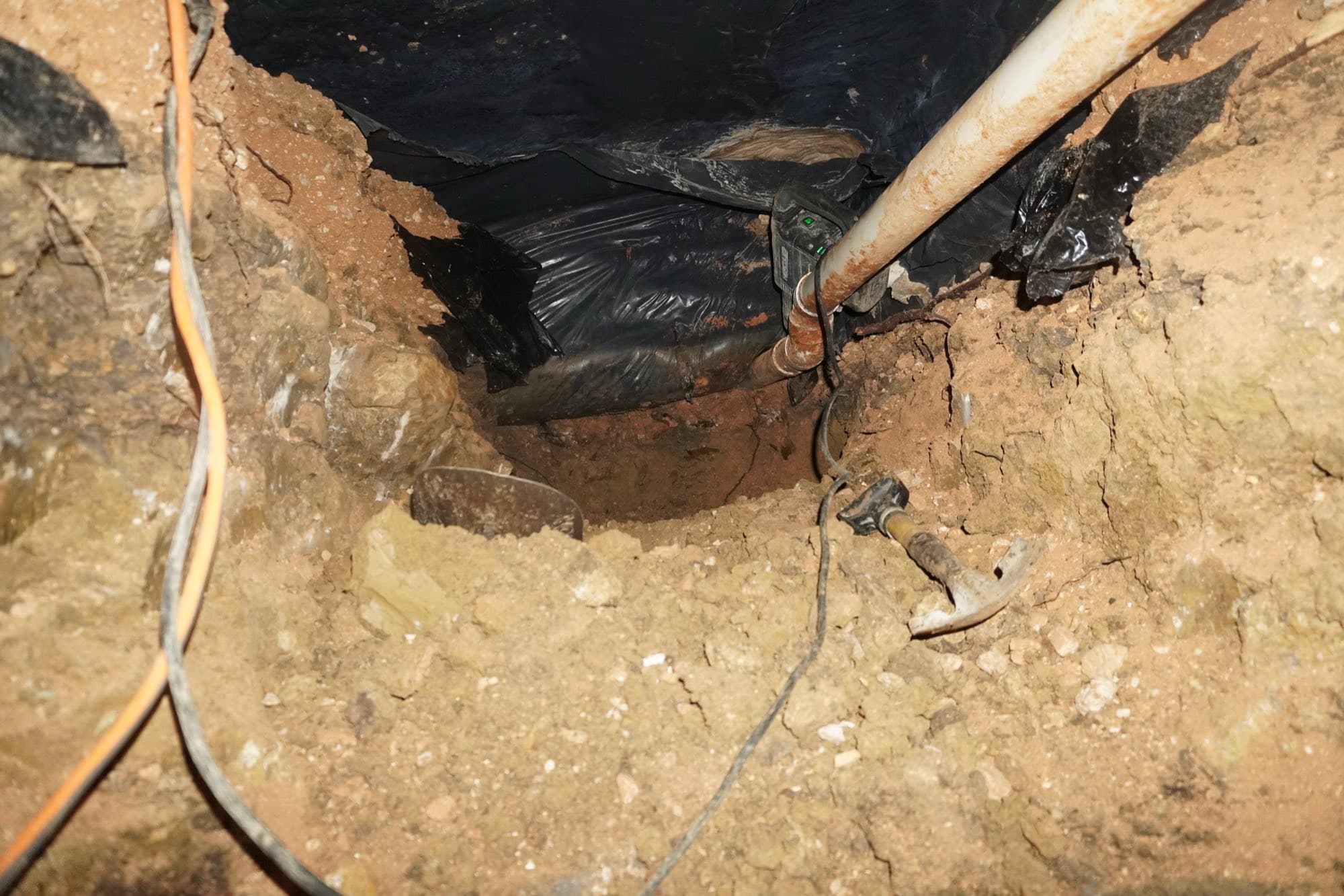 A repair in progress inside a tunnel excavated 25 feet beneath a concrete slab foundation