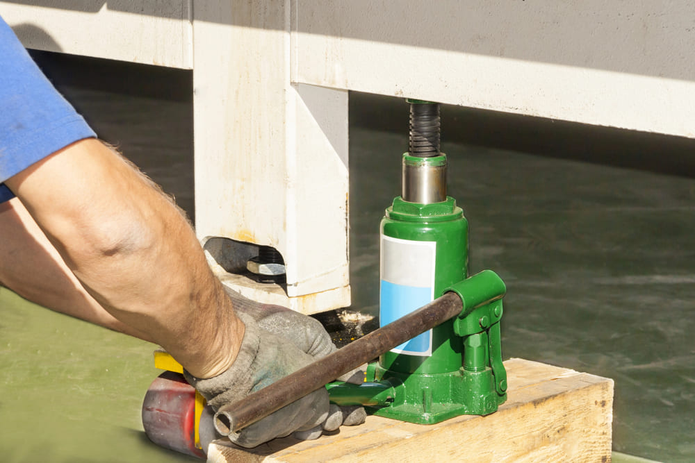 Man lifting using hydraulic floor jack