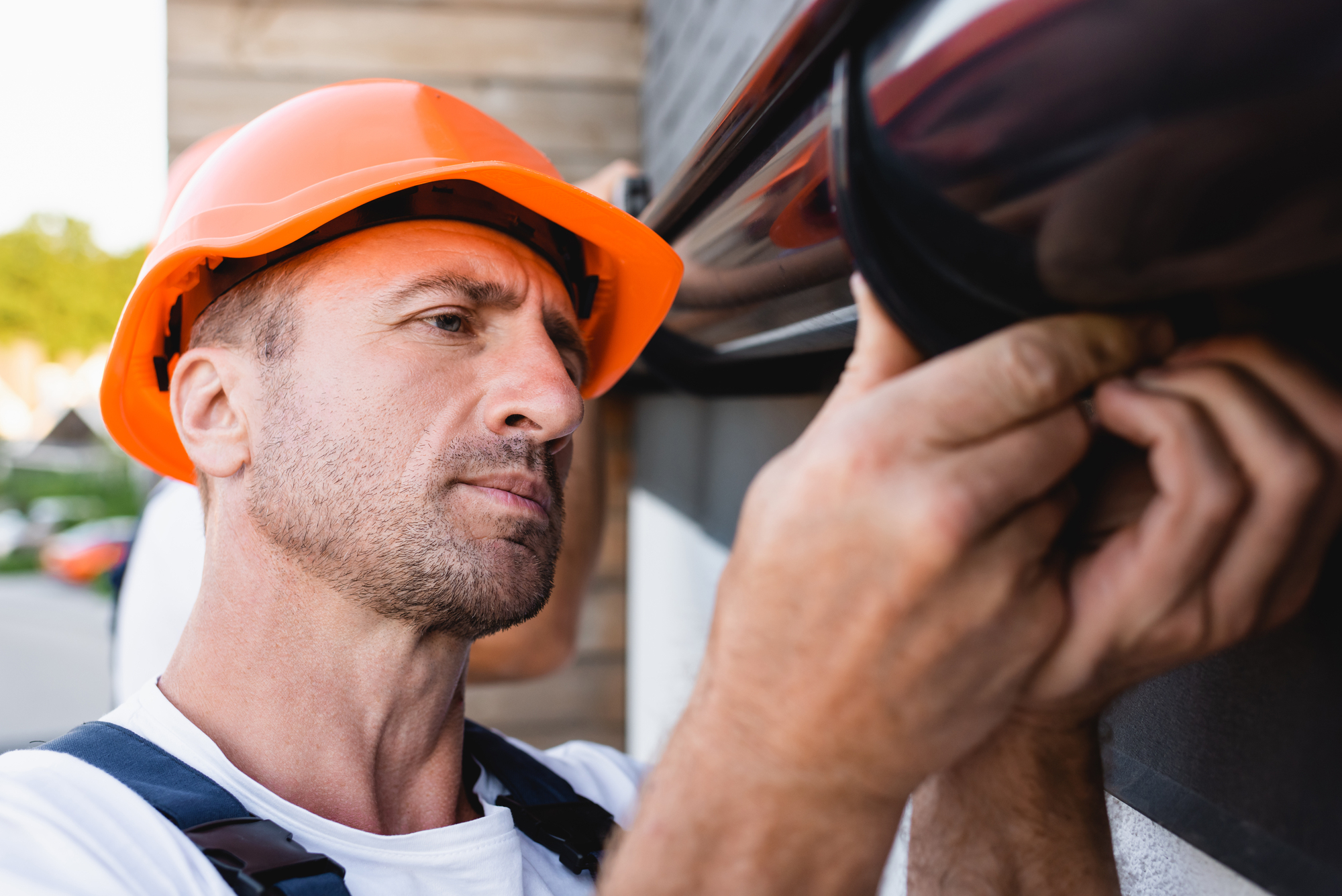 Selective focus of builder working with rain gutter