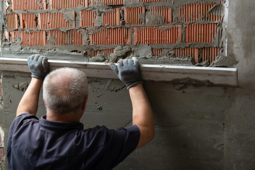 Man plastering wall. Worker makes renovation.